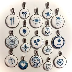 a group of nine pendants with different designs on them, all in blue and white