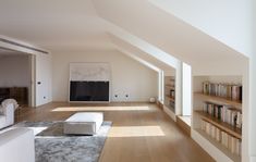 an empty living room with white furniture and bookshelves