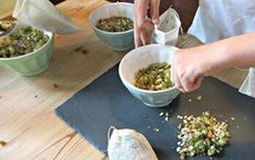 a person is preparing food in bowls on a table