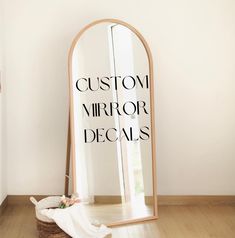 a large mirror sitting on top of a wooden floor next to a basket filled with flowers