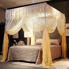 a canopy bed with sheer curtains and lights