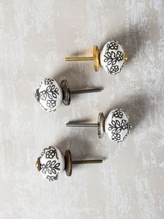 four decorative knobs with black and white designs on them