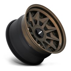 an image of a wheel that is on display in a studio setting, with the wheels and rims painted dark brown