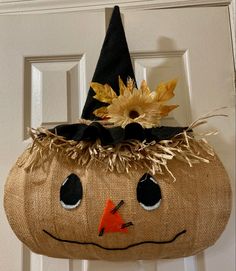 a burlocked pumpkin with a black hat on it's head hanging from a door