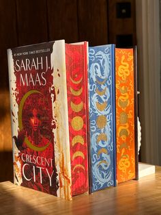 three books sitting on top of a wooden table