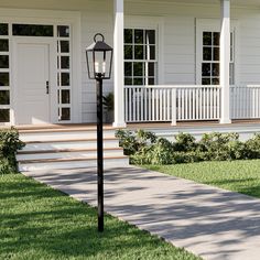 a lamp post in front of a house with steps leading up to the porch area