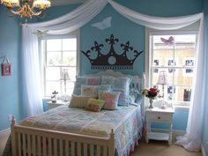 a bed room with a neatly made bed and a chandelier hanging from the ceiling