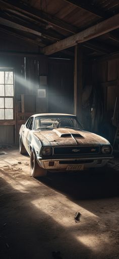 an old muscle car in a garage with sunlight coming through the window and on to the floor