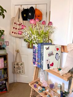 a shelf with flowers and other items on it in front of a white door,