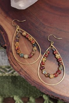 a pair of earrings sitting on top of a wooden table