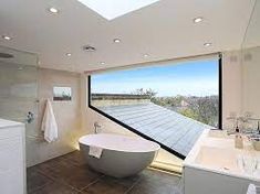 a large bathroom with a skylight above the bathtub