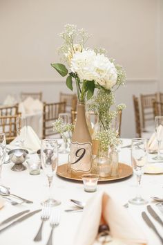 the table is set with flowers in vases and place settings for two people to sit at