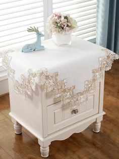 a white table with a flower vase on it