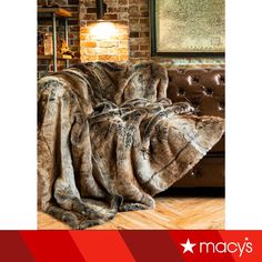 an image of a couch that is covered with a fur blanket and some lights in the background