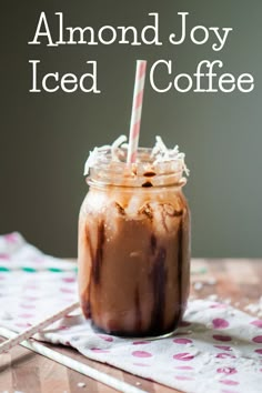 an iced coffee in a mason jar with a straw sticking out of it and the words almond joy iced coffee