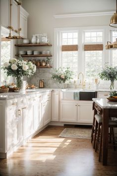 a kitchen filled with lots of white cabinets and counter top space next to a window