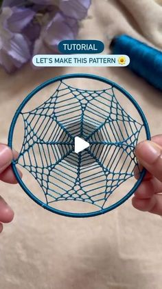 someone is holding up a circular object with blue thread on it and the text, let's make this pattern