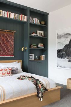 a bed sitting in a bedroom next to a book shelf