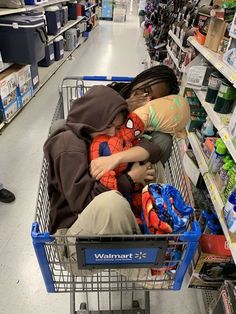 a person in a shopping cart with a spiderman on his back, hugging someone's face