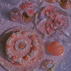 a table topped with a pink cake and lots of other items on top of it