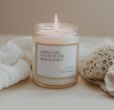 a candle sitting on top of a table next to a white towel and a bag