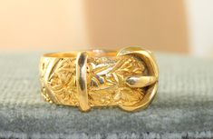 This is a substantial and well made Chased Buckle Ring in 18K yellow gold.  It is 8.6 grams in size 10.5.   It is 12 mm at the buckle and is hallmarked Birmingham, 1917 and 18K gold. Vintage Gold Engraved Ring, Gold Art Nouveau Ring For Formal Occasion, Art Nouveau Gold Engraved Rings, Art Nouveau Style Gold Engraved Rings, Art Nouveau Style Engraved Gold Rings, Buckle Ring, Bird Feathers, Rings Statement, Birmingham