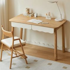 a wooden desk with a chair next to it and a lamp on the wall behind it