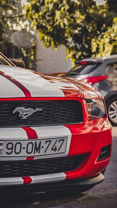 the front end of a red and white mustang