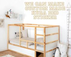 a wooden bunk bed sitting next to a white wall with the words we can make custom made kura bed sticker on it