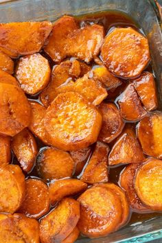 cooked sweet potatoes in a glass dish with brown liquid on top, ready to be eaten