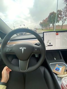 a person sitting in the driver's seat of a car using a laptop computer