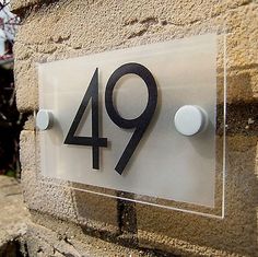 a house number sign mounted to the side of a building