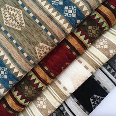 several different colored rugs are stacked on top of each other