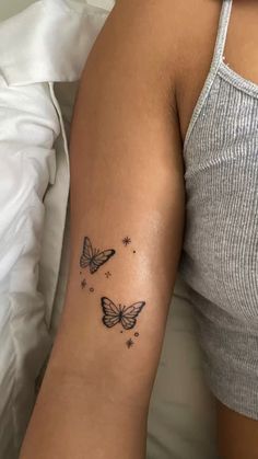 a woman's arm with a butterfly tattoo on the left side of her arm