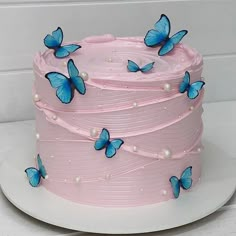 a pink cake with blue butterflies on it