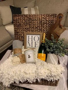 a wicker basket filled with wine, candles and other items sitting on top of a table