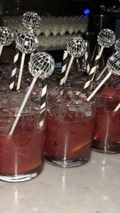 there are many cocktails on the table with lollipop sticks sticking out of them