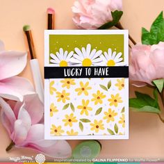 a close up of a card with flowers on it and some pencils next to it