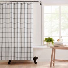 a black and white checkered shower curtain next to a bathtub in a bathroom