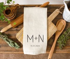 a kitchen towel with the word mmn printed on it next to wooden utensils