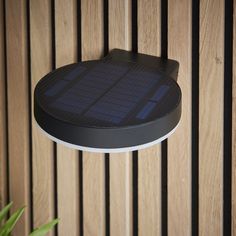 a solar powered light mounted on the side of a wooden wall