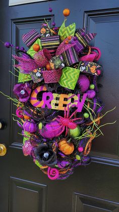 a halloween wreath hanging on the front door with words creepy written in purple and green