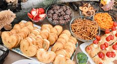 an assortment of pastries and desserts displayed on trays with teddy bears in the background