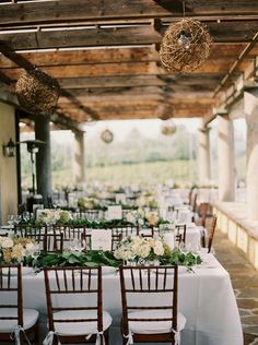 an outdoor dining area with tables and chairs set up for a formal dinner or party