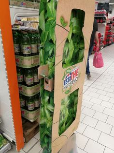 a cardboard sign that is made to look like a plant in a grocery store aisle