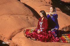 two women sitting on rocks in the desert