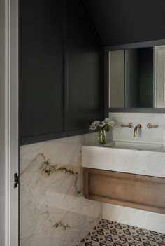 a bathroom with marble counter tops and black cabinets