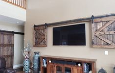 Special walnut Wall-mounted TV concealed with the wooden barn doors from the TV Hide package Barn Door Shutters, Bar Tv, Outdoor Tv Covers, Barn Door Cabinet, Barn Door Installation, Sliding Shutters, Tv Covers, Hidden Tv, Barn Door Kit