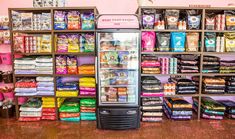 a vending machine sitting in front of a display case filled with candy and snacks