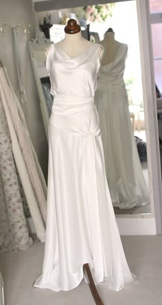 a white dress on display in front of a mirror